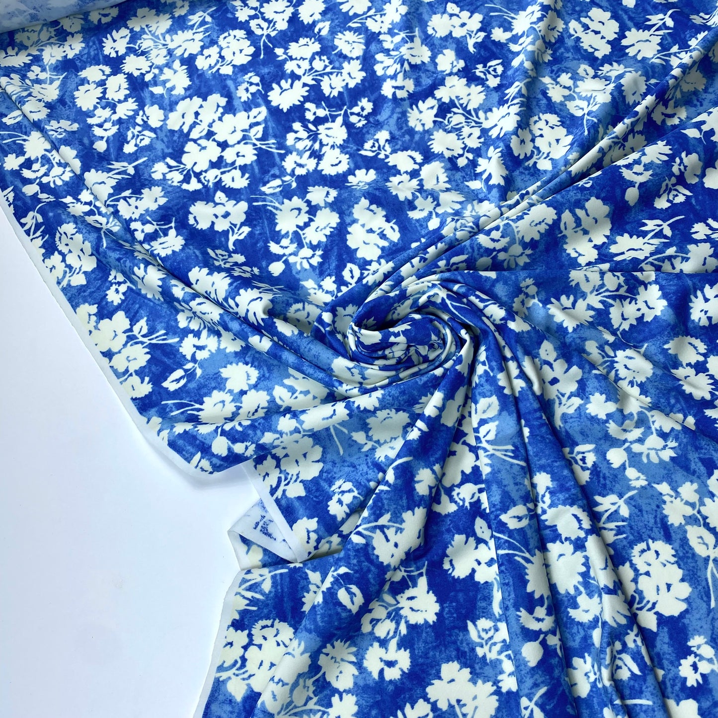Tela de lycra azul con flores blancas