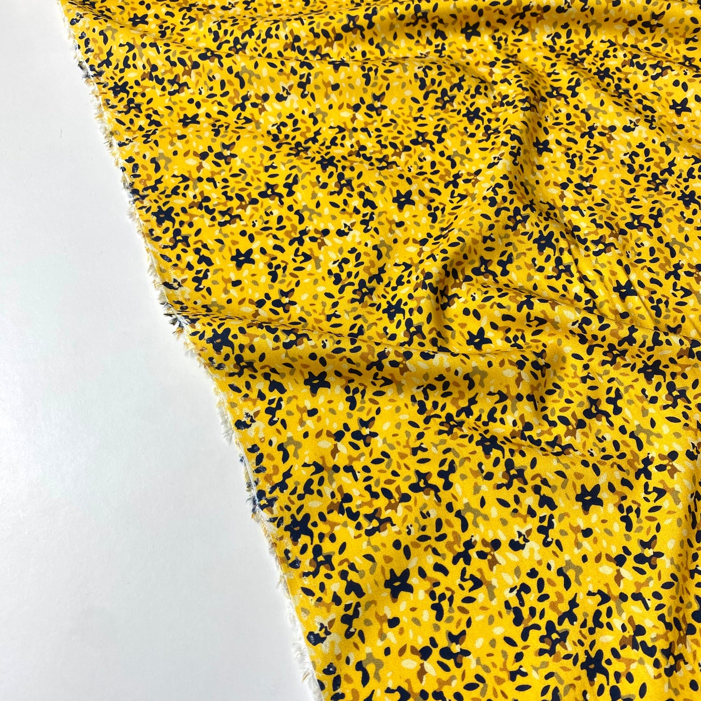 Yellow viscose with blue, green, brown, and beige spots.