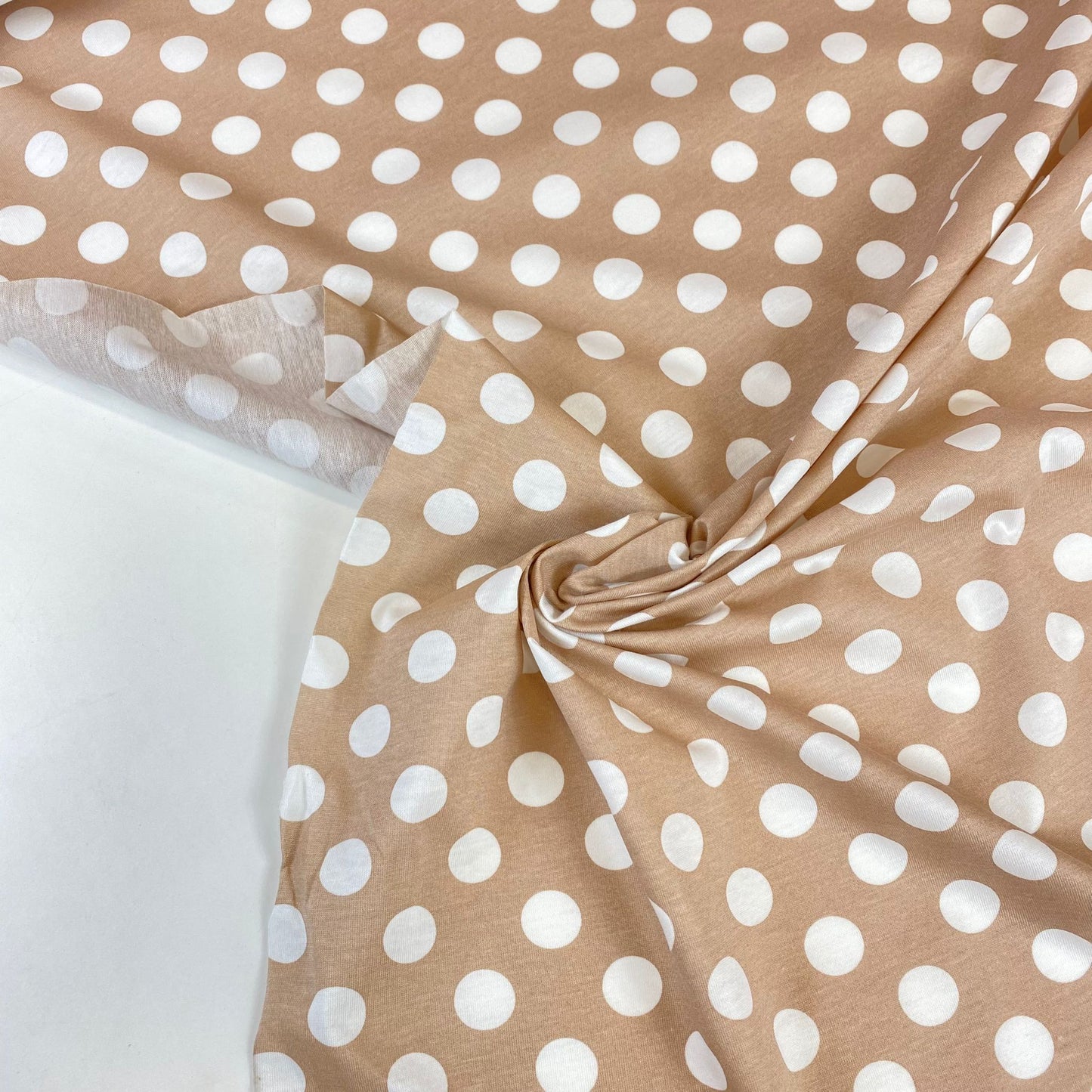 Beige jersey with white polka dots and elastane.