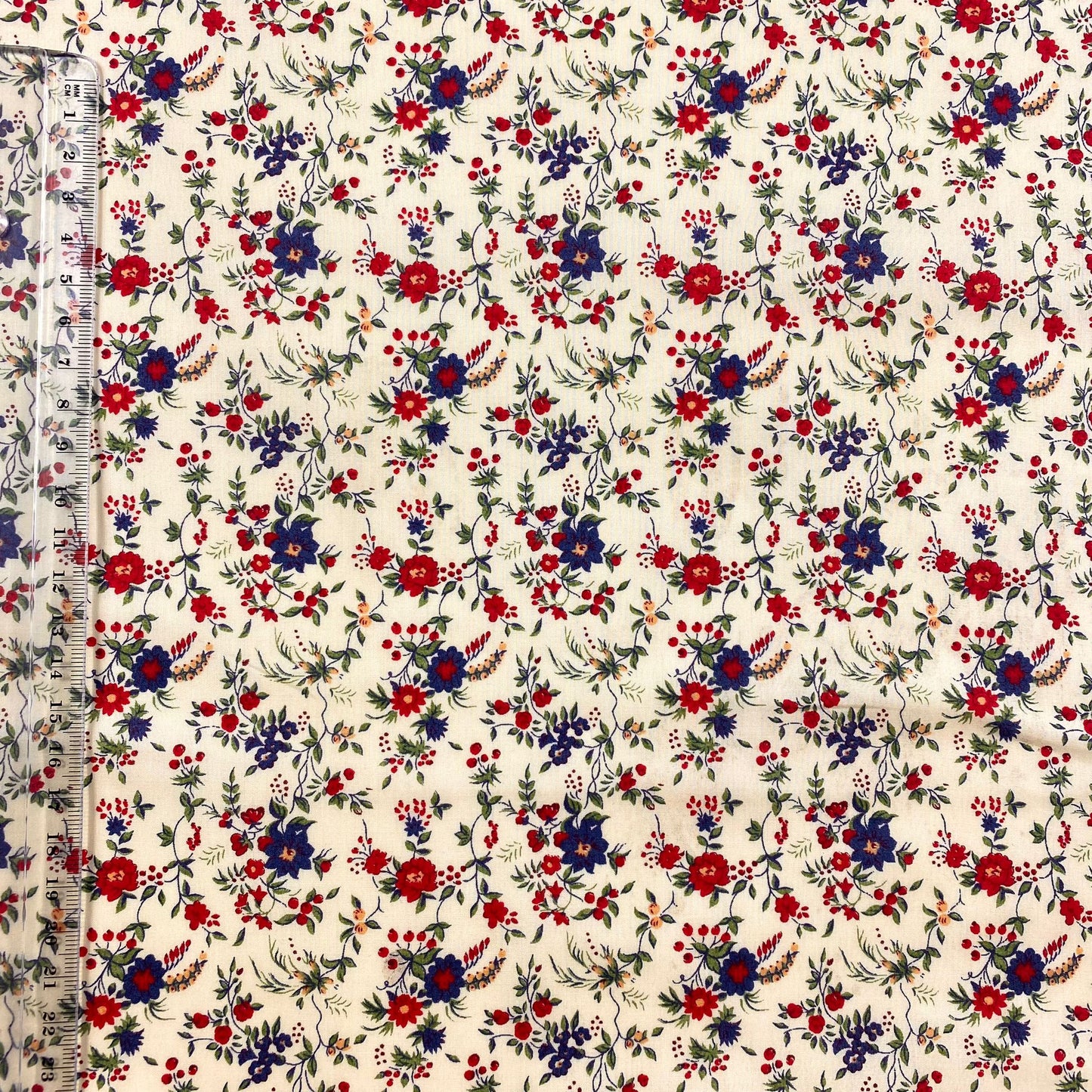 Popelín crema con flores azules y rojas