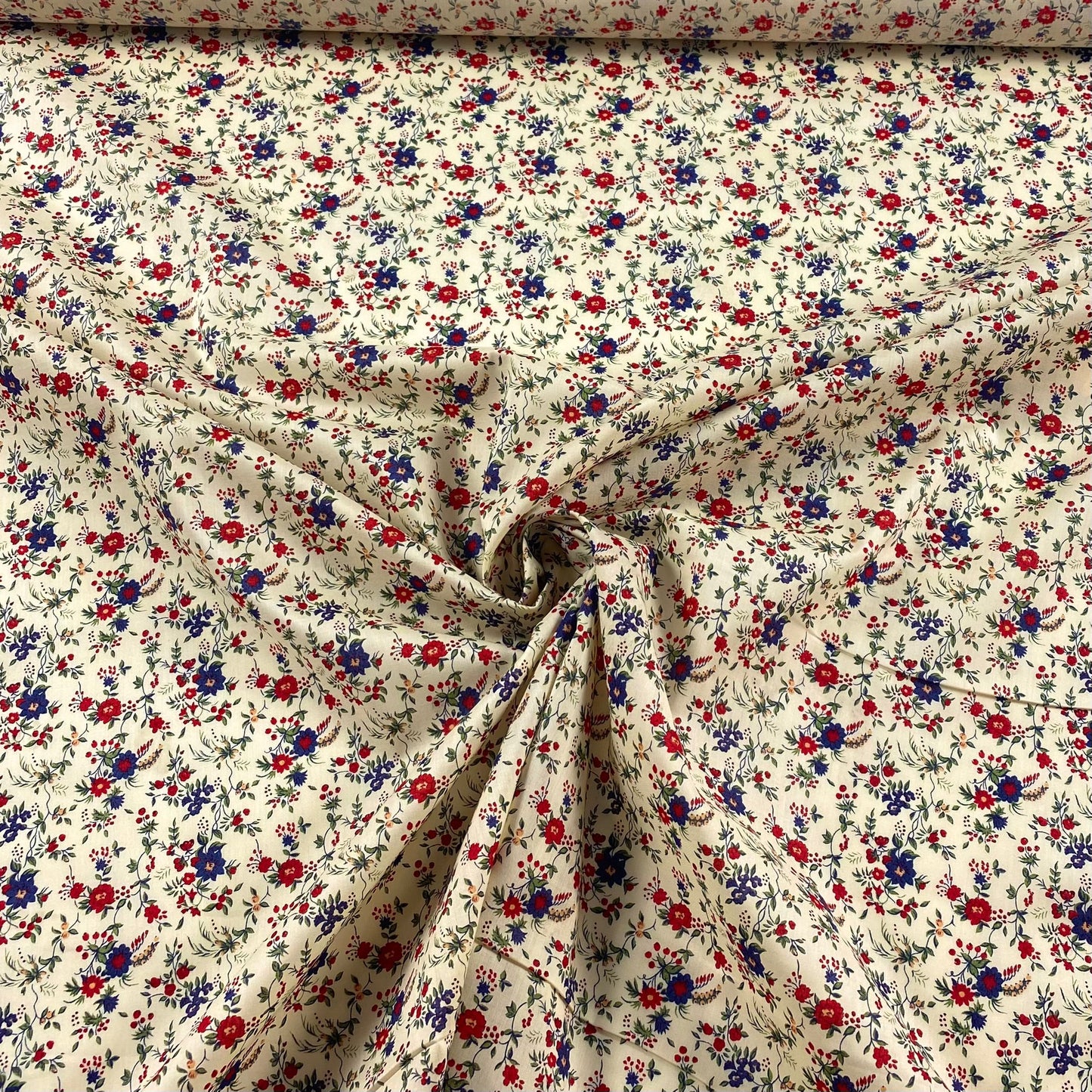 Popelín crema con flores azules y rojas