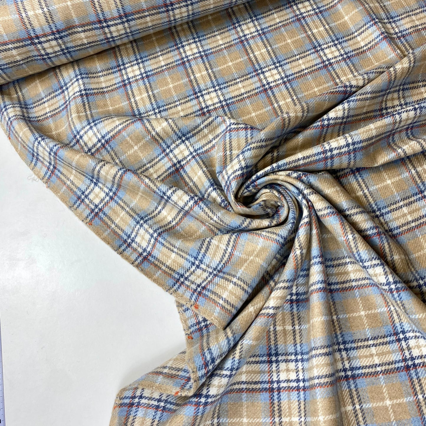 Tejido fino en tonos beige, celeste y rayas.