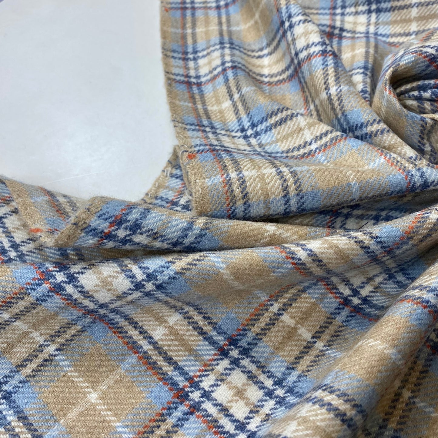 Tejido fino en tonos beige, celeste y rayas.