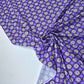 Tejido de punto lycra con fondo morado y flores verdes y lilas.