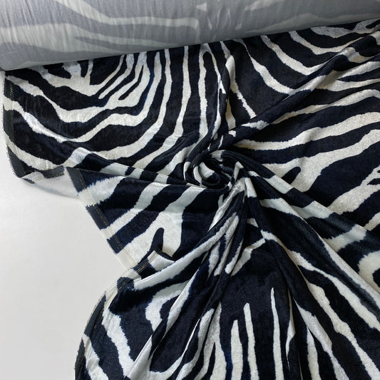 Tejido aterciopelado con estampado de cebra en blanco y negro.