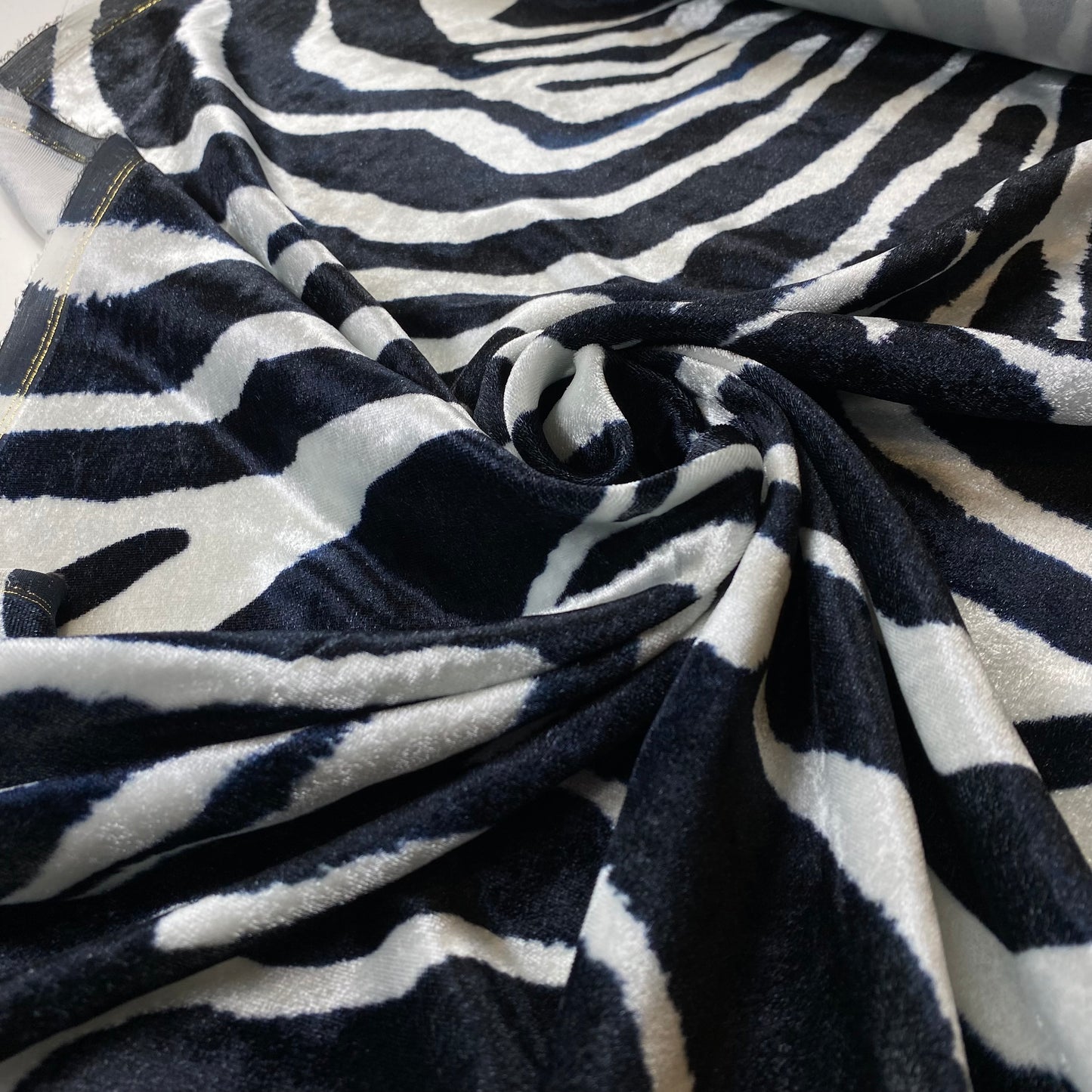 Tejido aterciopelado con estampado de cebra en blanco y negro.