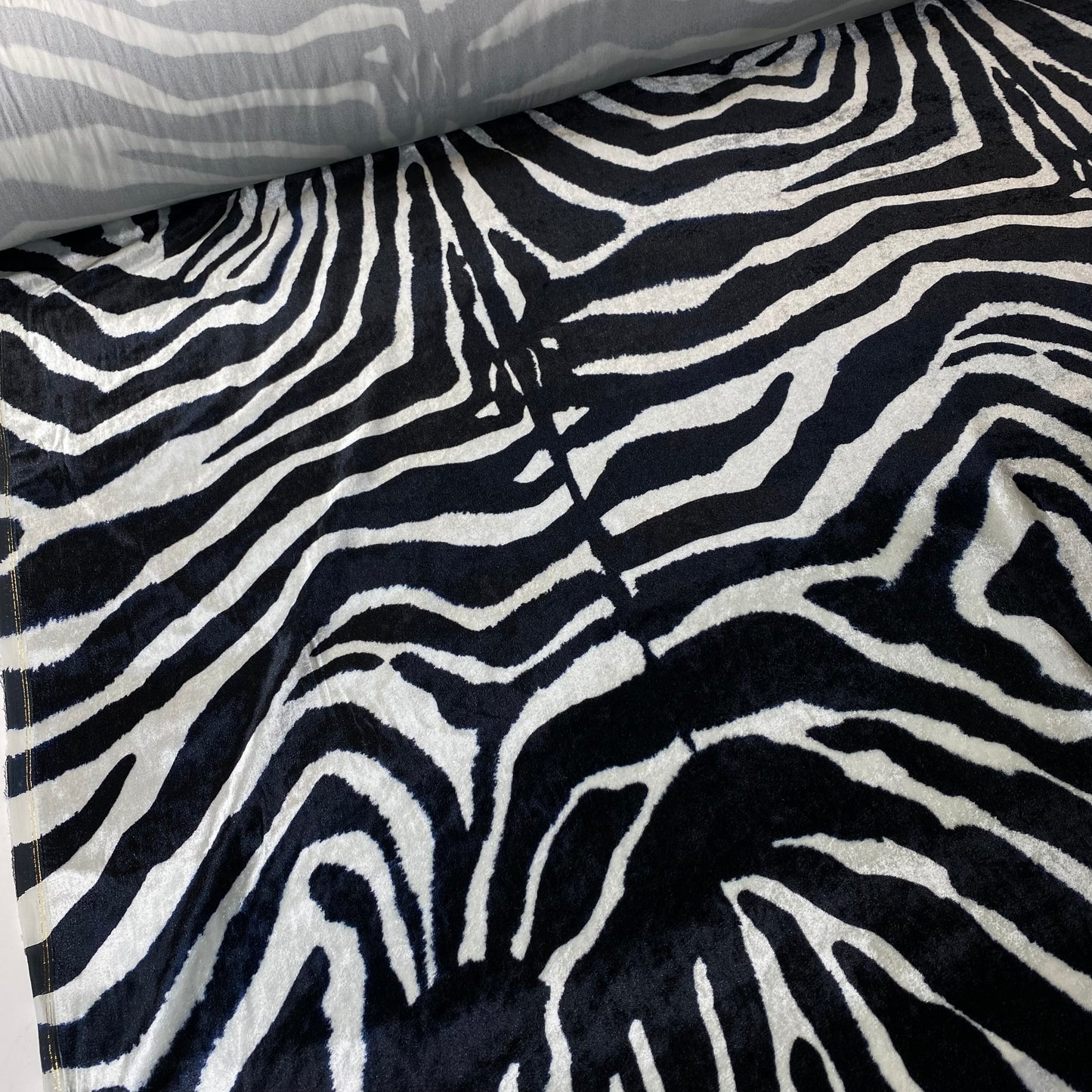 Tejido aterciopelado con estampado de cebra en blanco y negro.