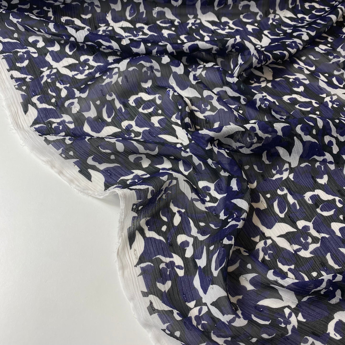 Tafetán negro con flores moradas y blancas y brillo.