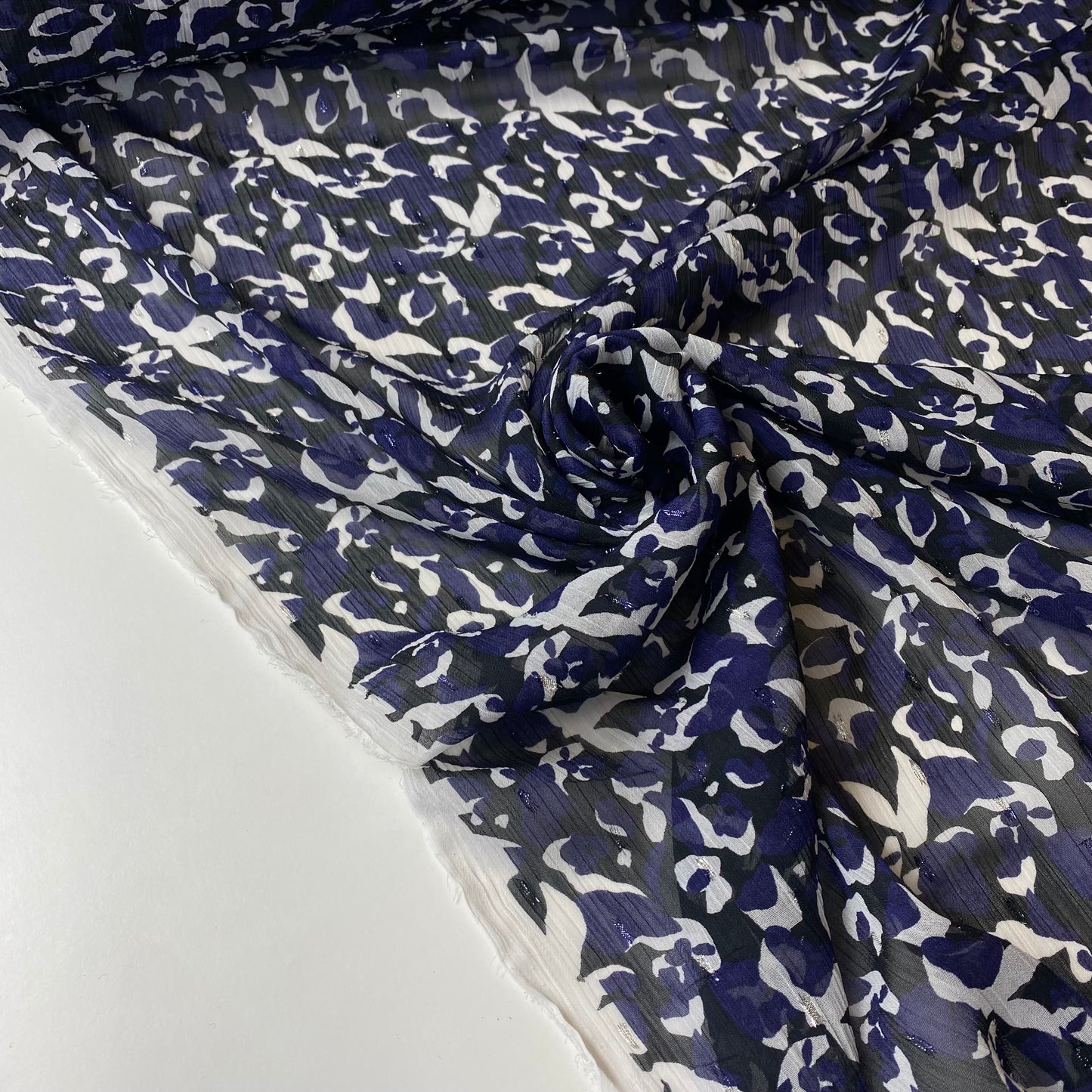 Tafetán negro con flores moradas y blancas y brillo.