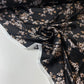 Satén negro con flores blancas y beige.