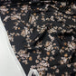 Satén negro con flores blancas y beige.