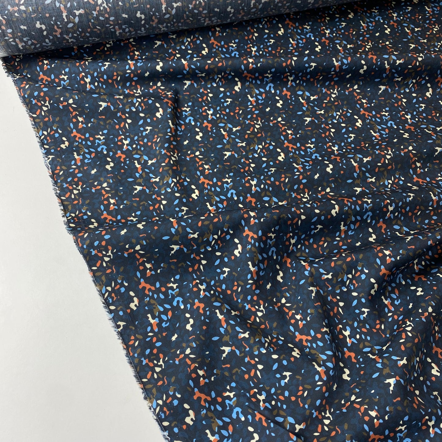 Navy blue poplin with orange, blue, and beige spots.