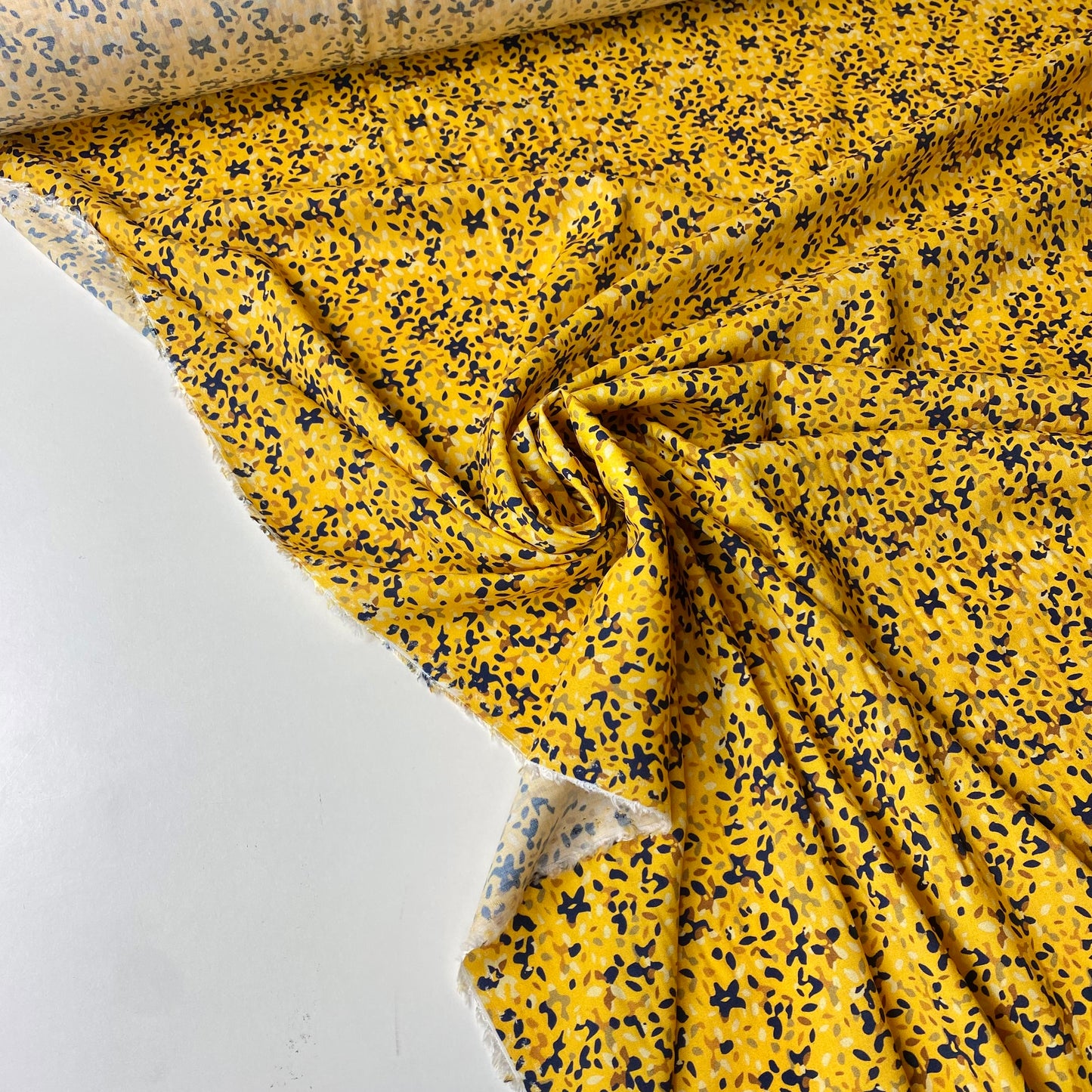 Viscosa amarilla con manchas azules, verdes, marrones y beige.