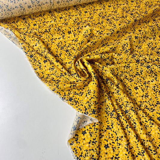 Viscosa amarilla con manchas azules, verdes, marrones y beige.