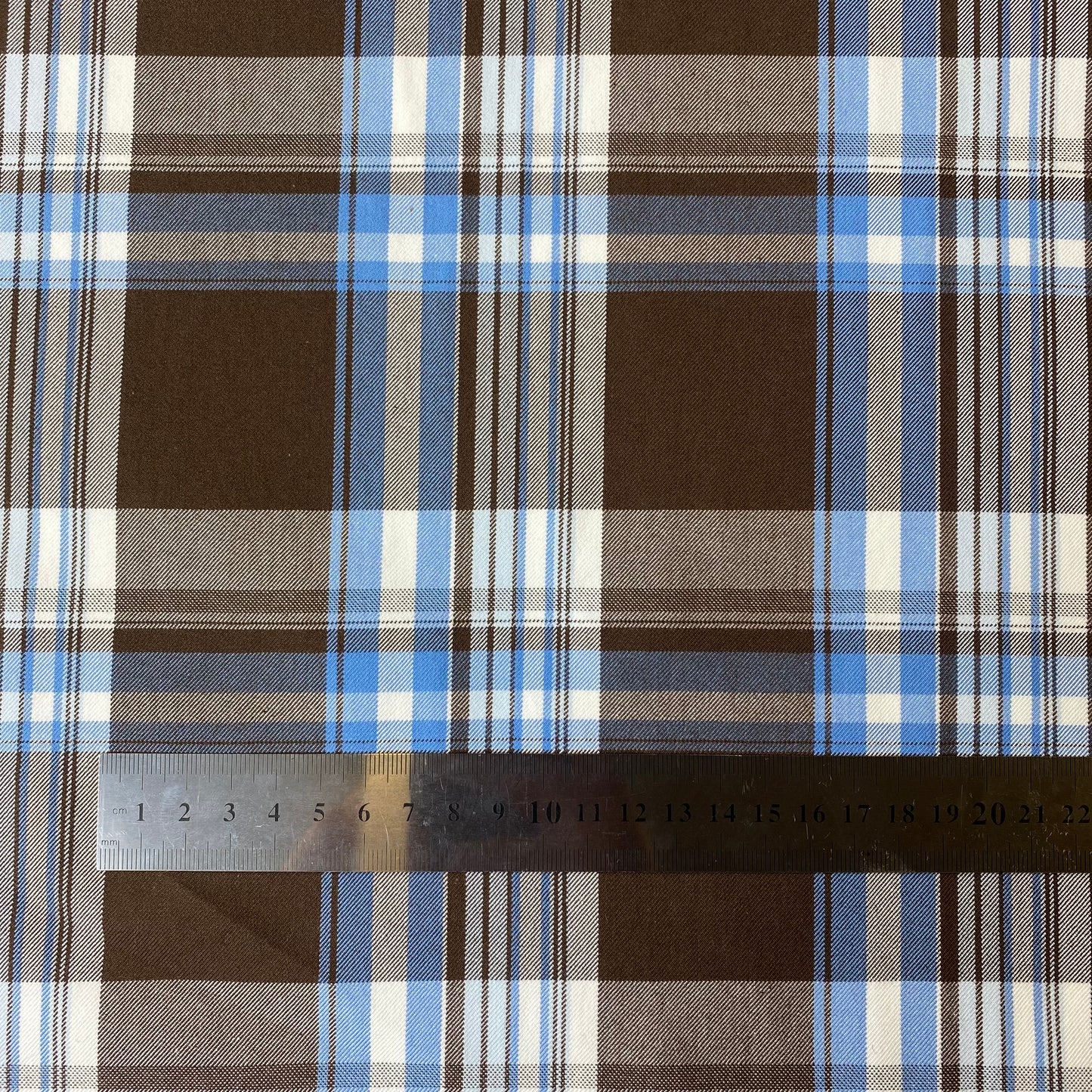 Tela de sarga cuadrada de color marrón con rayas blancas y azules.