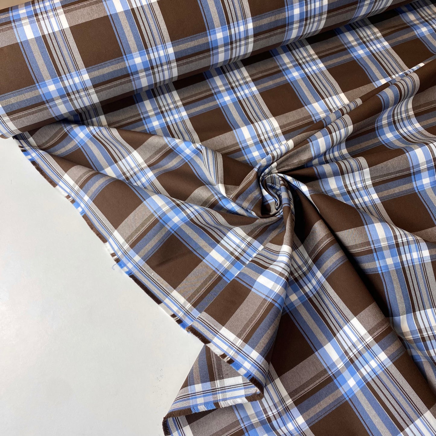 Tela de sarga cuadrada de color marrón con rayas blancas y azules.