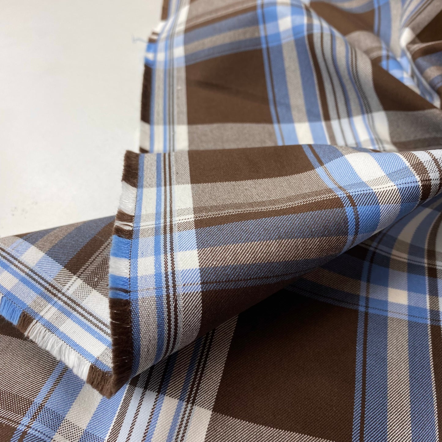 Tela de sarga cuadrada de color marrón con rayas blancas y azules.