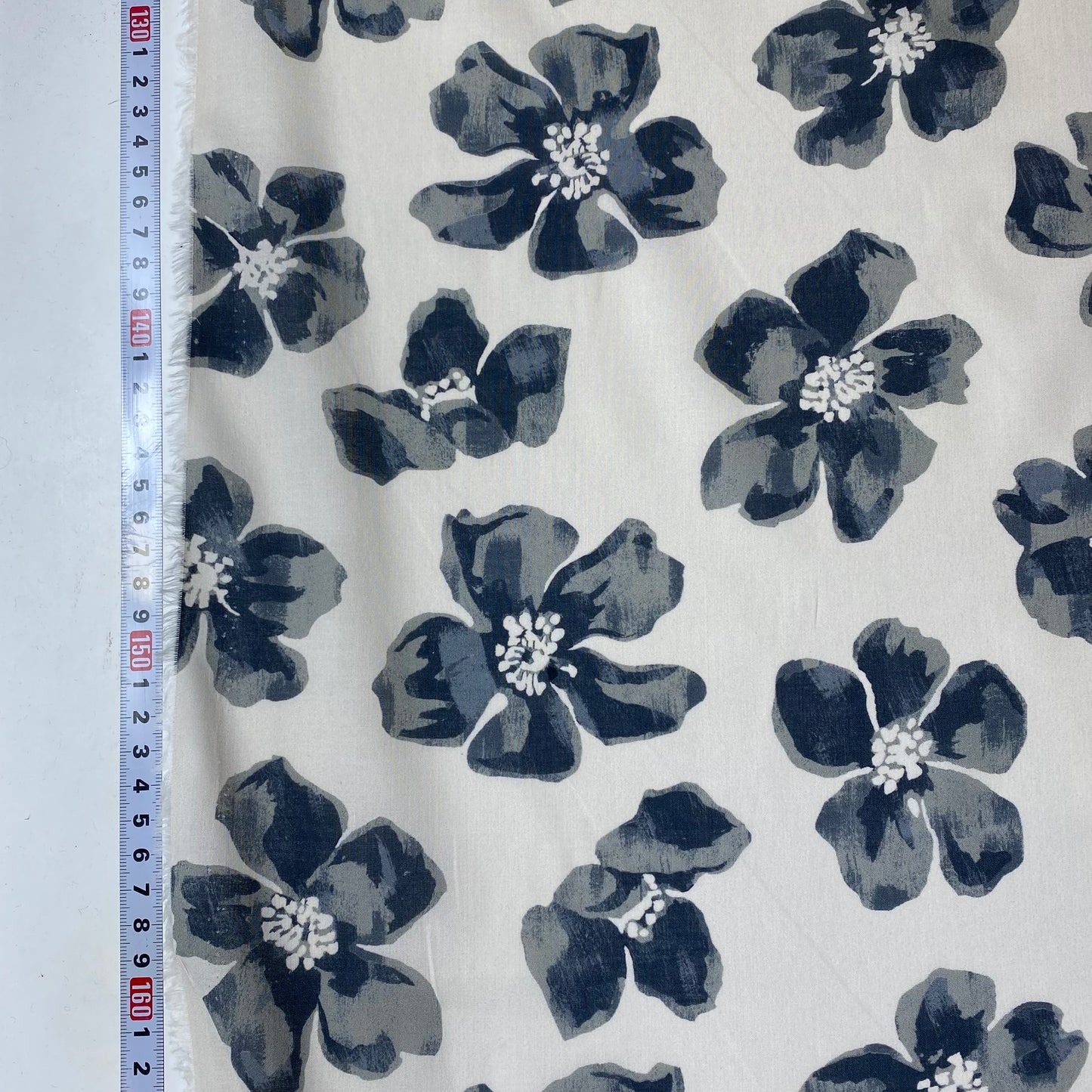 Voile de color blanco grisáceo con flores grises.