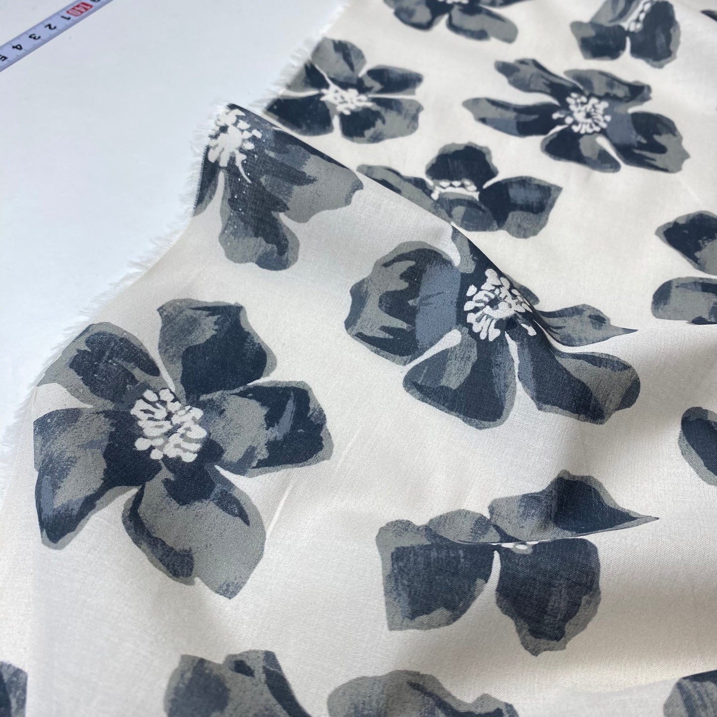 Voile de color blanco grisáceo con flores grises.