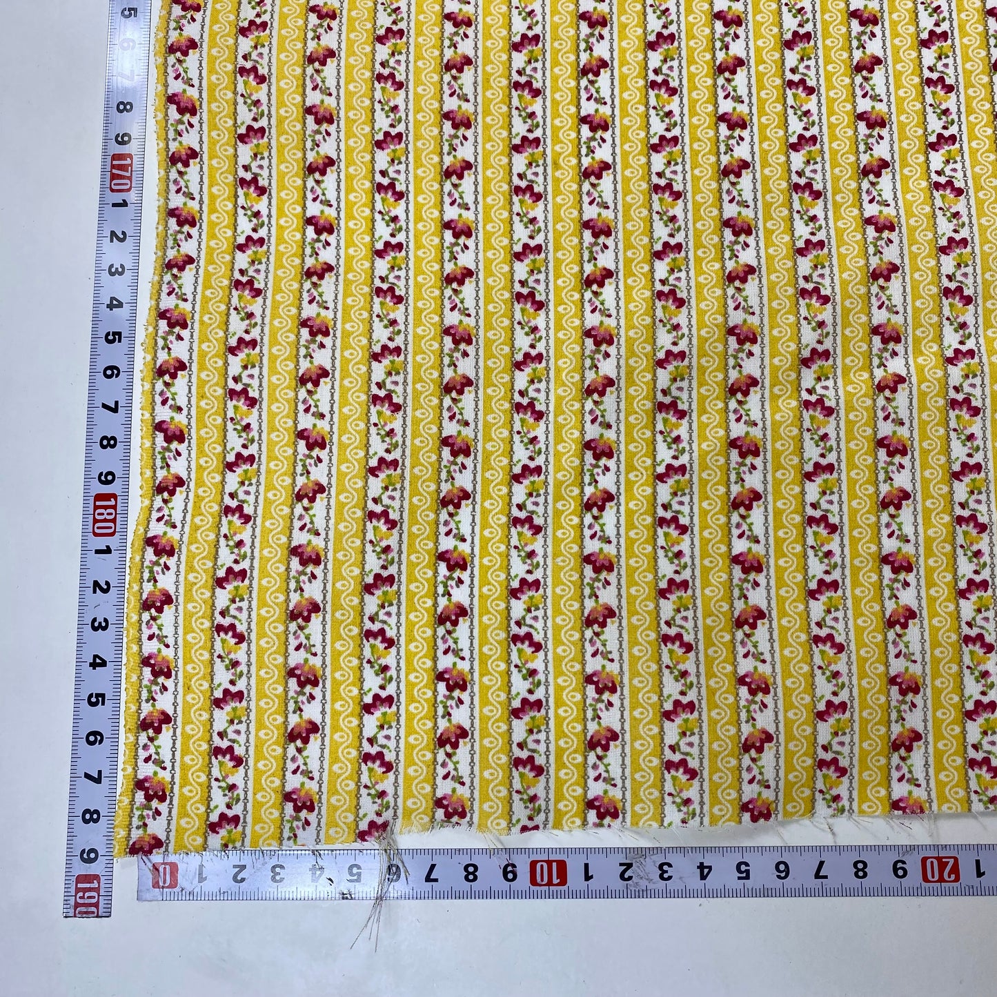 Chintz de Alcobaça con rayas amarillas y blancas y flores rojas.