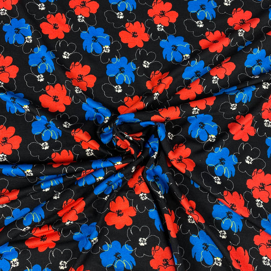 Jersey de viscosa negro con flores azules y rojas.